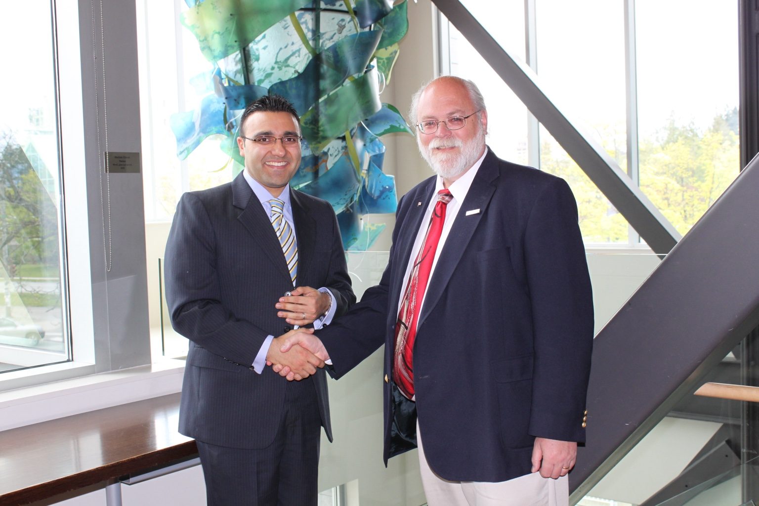 A ceremonial handshake during the 2011 Kanani Conference Rooms dedication event